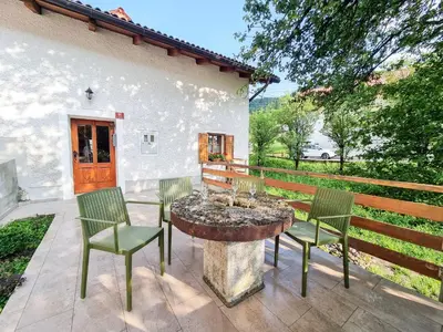 a patio with chairs and a table with a fountain at Country House Lastovka in Tolmin