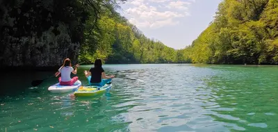 three women are kayaking down a river on a river at Country House Lastovka in Tolmin