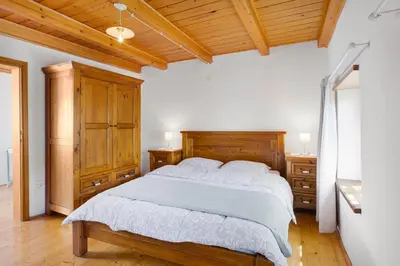 a bedroom with a large bed and wooden cabinets at Country House Lastovka in Tolmin