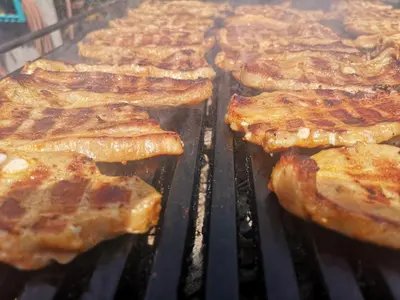 a group of bacon cooking on a grill at Gostilna in apartmaji Zlati lev - Maribor in Maribor