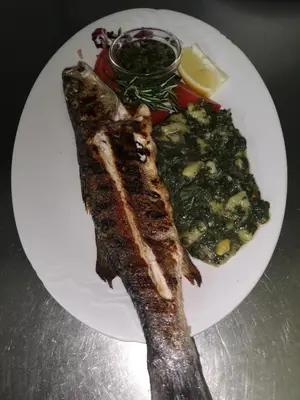 a plate of food with fish and vegetables on it at Gostilna in apartmaji Zlati lev - Maribor in Maribor