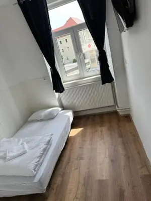 a small bedroom with a bed and a window at Gostilna in apartmaji Zlati lev - Maribor in Maribor