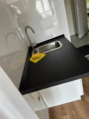a kitchen counter with a sink and a yellow tag at Gostilna in apartmaji Zlati lev - Maribor in Maribor