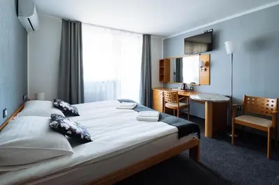 a hotel room with a large bed and a desk at Hotel GH Kolinska in Bled