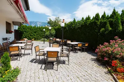a group of tables and chairs on a patio at Hotel GH Kolinska in Bled