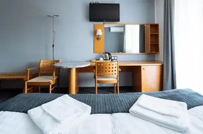 a bedroom with a bed and a desk and a table at Hotel GH Kolinska in Bled