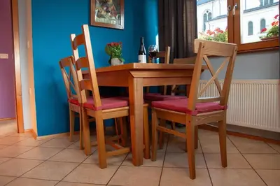 a dining room table with four chairs and a table with flowers at Apartma Burk in Kobarid