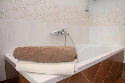 a bathroom with a white bath tub with a towel at Apartma Burk in Kobarid