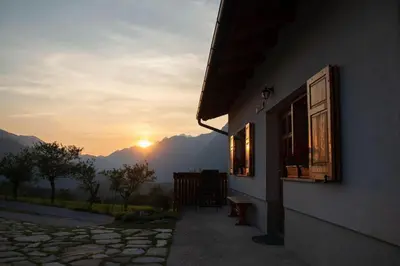 a building with a window with the sunset in the background at Apartma Burk in Kobarid