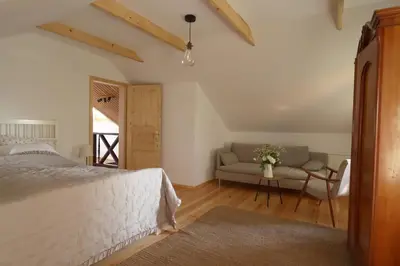 a bedroom with a bed and a couch at Hiška pod Klumpo in Ormoz