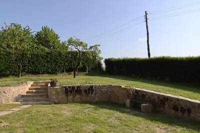a stone retaining wall with stairs in a yard at Hiška pod Klumpo in Ormoz
