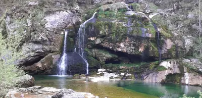 a waterfall on the side of a rocky mountain at Pri Ani Ruscovi in Bovec