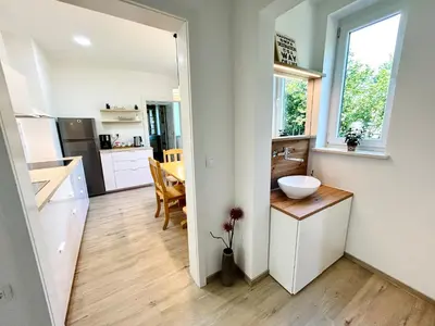 a kitchen and dining room with a sink and a table at Creekside House K in Mozirje