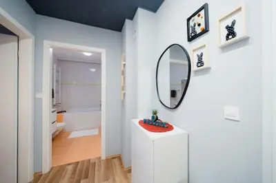 a white bathroom with a mirror and a sink at Cosy apartment in Divača