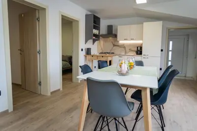 a kitchen and dining room with a white table and chairs at Cuckoo's Alpine Nest in Lesce