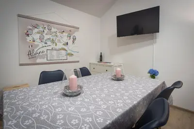 a dining room table with two candles and a tv at Cuckoo's Alpine Nest in Lesce