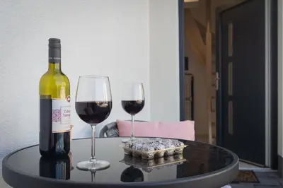 a bottle of wine and two glasses on a table at Cuckoo's Alpine Nest in Lesce