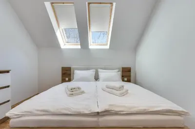 a bedroom with a white bed with two towels on it at Chic Apartments with Finnish Sauna and Jacuzzi in Kranjska Gora