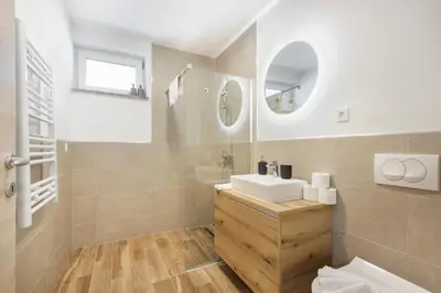 a bathroom with a sink and a mirror at Chic Apartments with Finnish Sauna and Jacuzzi in Kranjska Gora