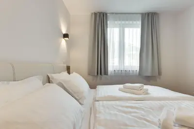 two beds in a bedroom with white sheets and towels at Chic Apartments with Finnish Sauna and Jacuzzi in Kranjska Gora