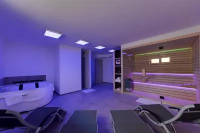 a bathroom with a tub and chairs in it at Chic Apartments with Finnish Sauna and Jacuzzi in Kranjska Gora