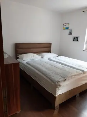 a bedroom with a large bed with a wooden headboard at Apartma Mira in Zgornje Škofije