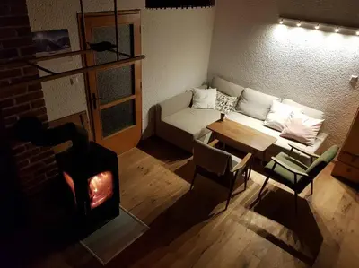 a living room with a couch and a fireplace at Cosy countryside cottage with indoor fireplace in Sodražica