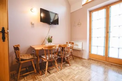a dining room with a table and chairs and a tv at POČITNIŠKI APARTMAJI - Vijolica 2 in Moravske Toplice in Moravske Toplice