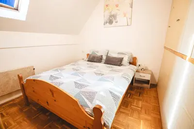 a bedroom with a bed with a wooden floor at POČITNIŠKI APARTMAJI - Vijolica 2 in Moravske Toplice in Moravske Toplice