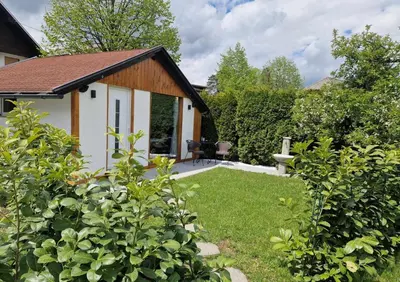 a garden with a small house with a yard at Lodge Pia in Bled