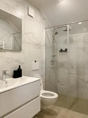 a bathroom with a shower and a toilet and a sink at Lodge Pia in Bled
