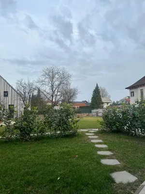 a path in a yard with some bushes and trees at Lodge Pia in Bled
