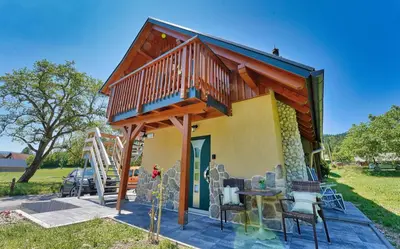 a small house with a deck and a table and chairs at Betlehem Resort in Zgornje Gorje