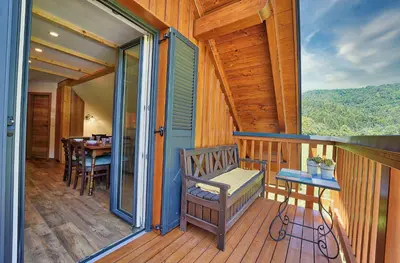 a porch with a chair and a table on a house at Betlehem Resort in Zgornje Gorje