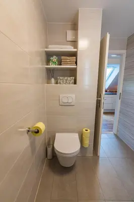 a bathroom with a white toilet in a room at UpArt Bled in Bled