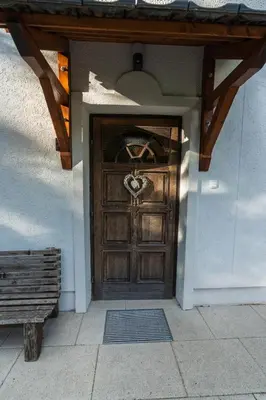 a wooden door to a building with a bench at UpArt Bled in Bled