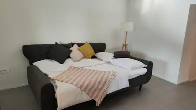 a bed with pillows on it in a room at Šilarjeva huba Apartment in Bohinjska Bistrica