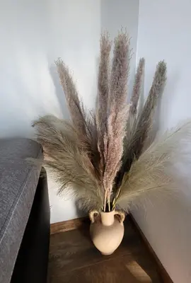 a vase filled with feathers sitting on a floor at Under The Castle in Dob