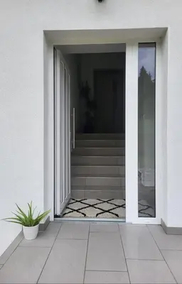 an open glass door of a house with stairs at Under The Castle in Dob