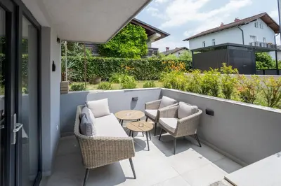 a patio with chairs and a table on a balcony at The Nice Apartment in Domžale