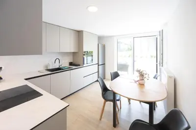 a kitchen and dining room with a table and chairs at The Nice Apartment in Domžale