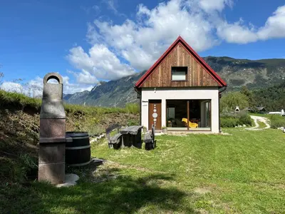 a small house sitting on top of a lush green field at Holiday home Dreams in Kobarid