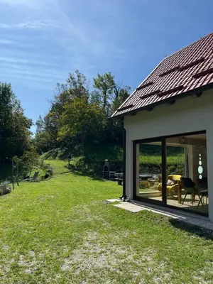 a house with a large glass window next to a yard at Holiday home Dreams in Kobarid