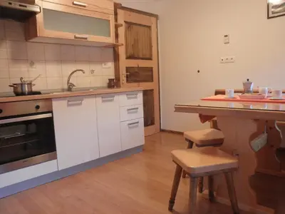 a kitchen with white cabinets and a sink and a counter at Apartments Čumar in Cerkno