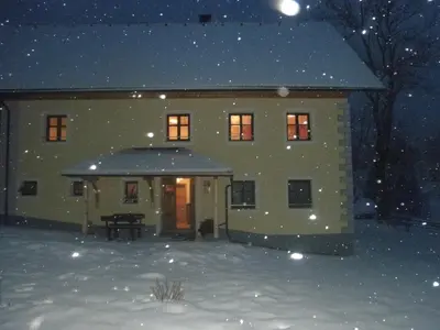 a house in the snow at night at Apartments Čumar in Cerkno