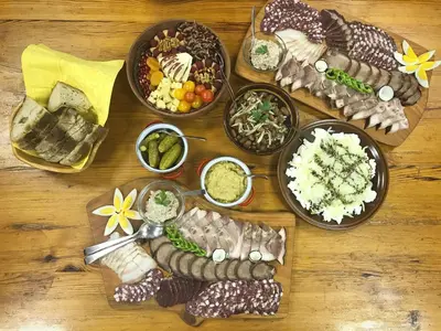 a wooden table topped with different types of food at Country House Apat in Šoštanj