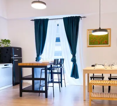 a dining room with a table and chairs and a window at Aumetz square apartment in Idrija