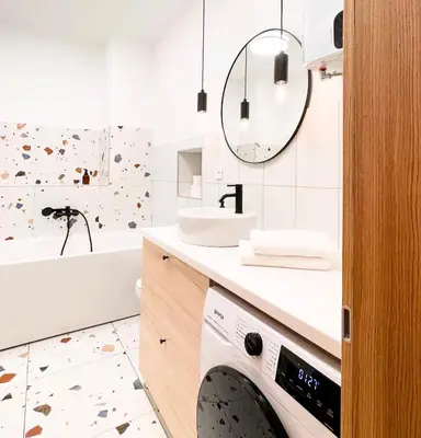 a bathroom with a sink and a washing machine at Aumetz square apartment in Idrija