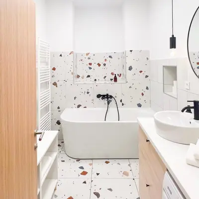 a white bathroom with a tub and a sink at Aumetz square apartment in Idrija