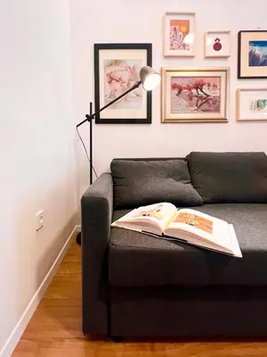 a book on a couch with a lamp on it at Aumetz square apartment in Idrija